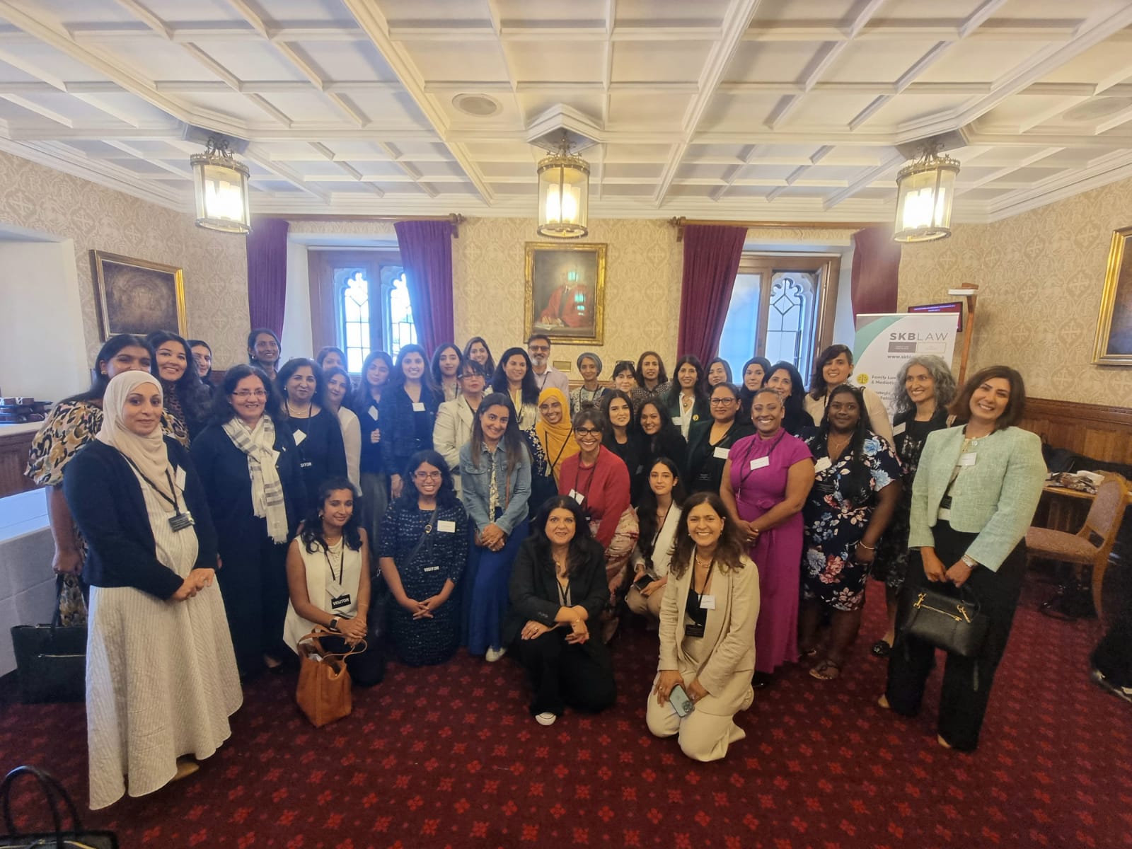 a group of South Asian women stand in a semi circle at the House of Lords